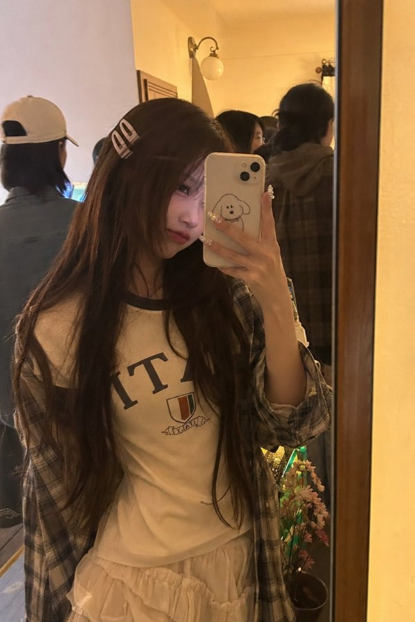 此为一张清新写实风格的照片，拍摄场景是一个略显拥挤的房间。落地镜旁边站着一位长发...